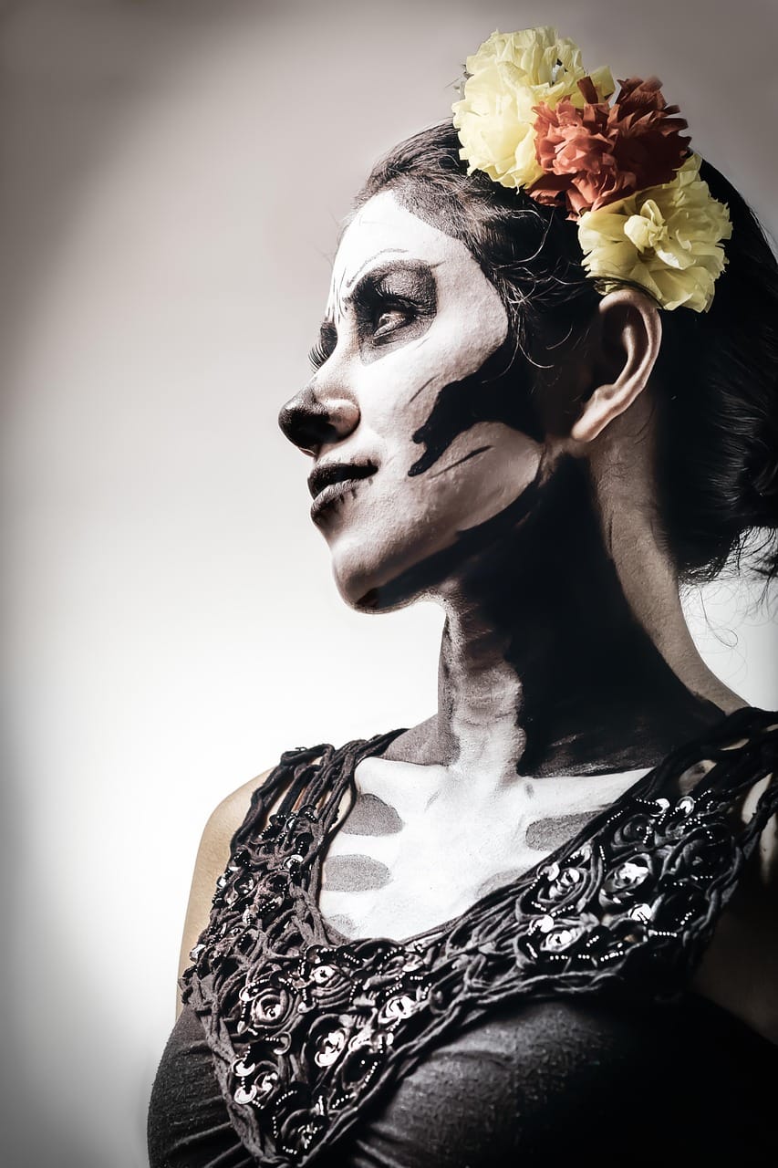 Photo of young Hispanic woman in Calavera makeup and a flower crown for Day of the Dead celebration