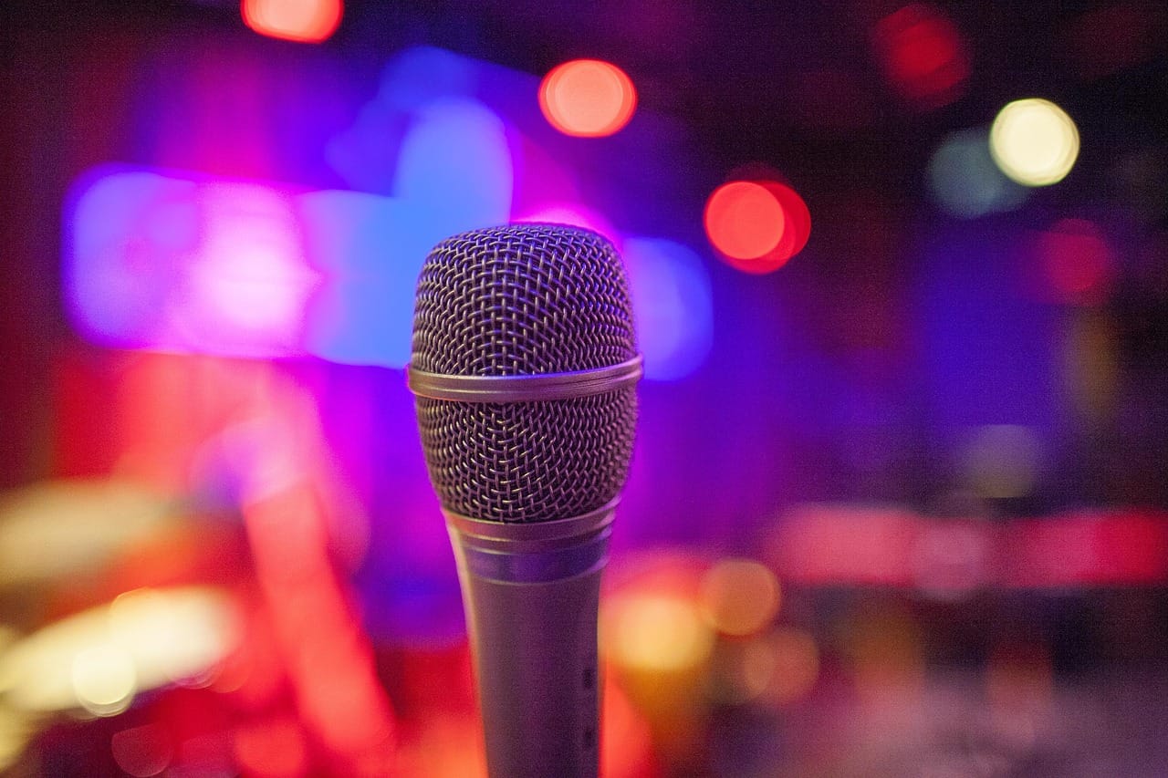 Closeup of microphone with red and blue lights in the background
