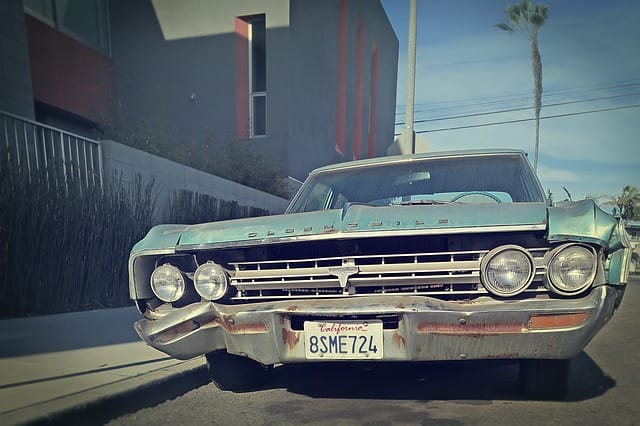 Beat up vintage blue Oldsmobile with California plates