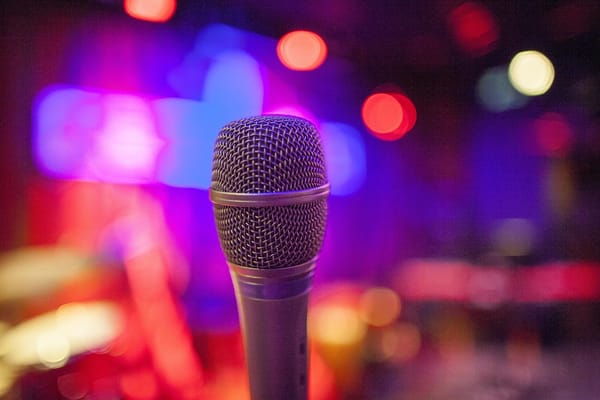 Closeup of microphone with red and blue lights in the background